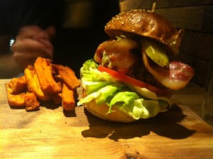 Steak burger with streaky bacon and cheddar cheese and sweet potato fries